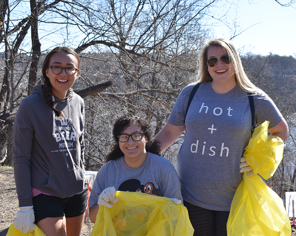 Three women with trash bags