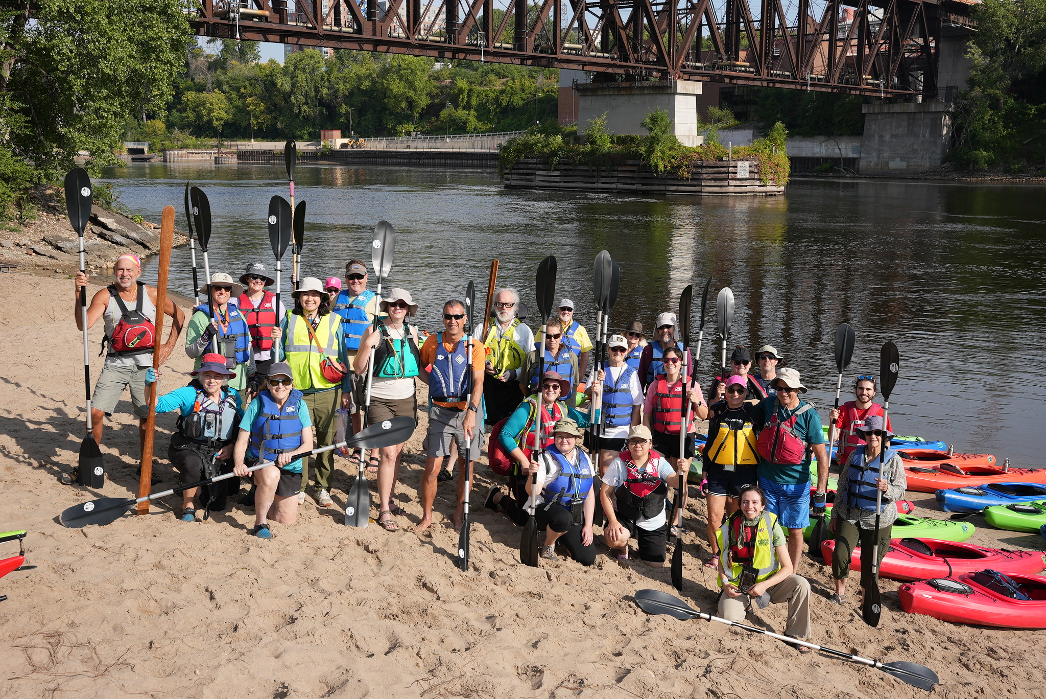 Kayaker volunteers with paddles on the river shore