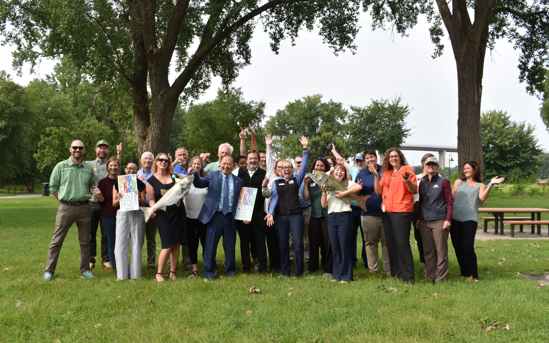 Coalition members, legislators and agency staff all pose for a celebratory photo outside at Harriet Island.