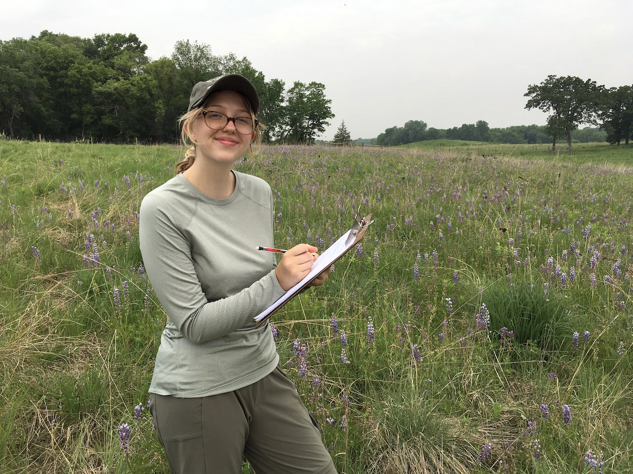 Annika Brelsford with a clipboard in the prairie