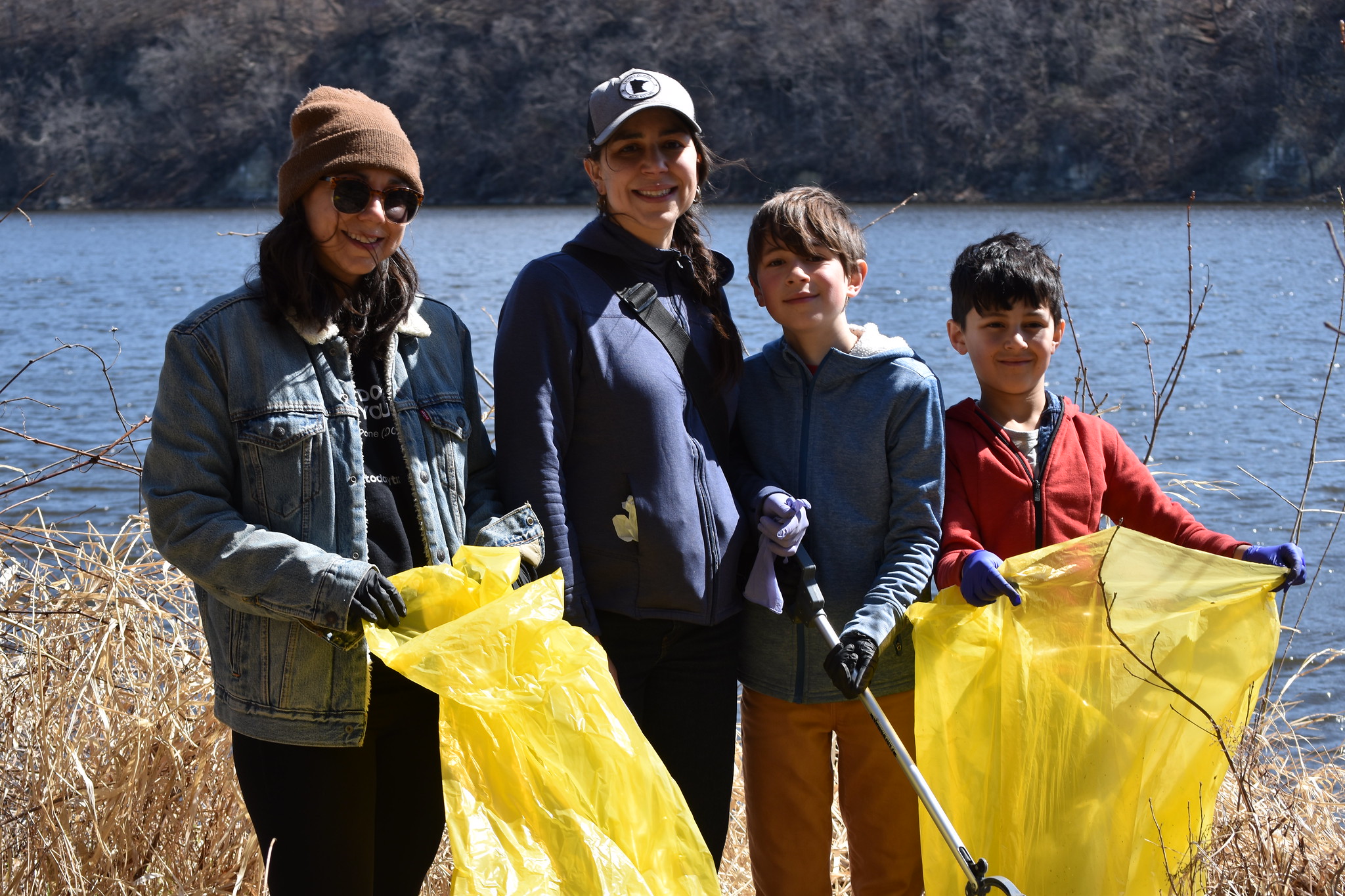 Volunteers with bags stand by river