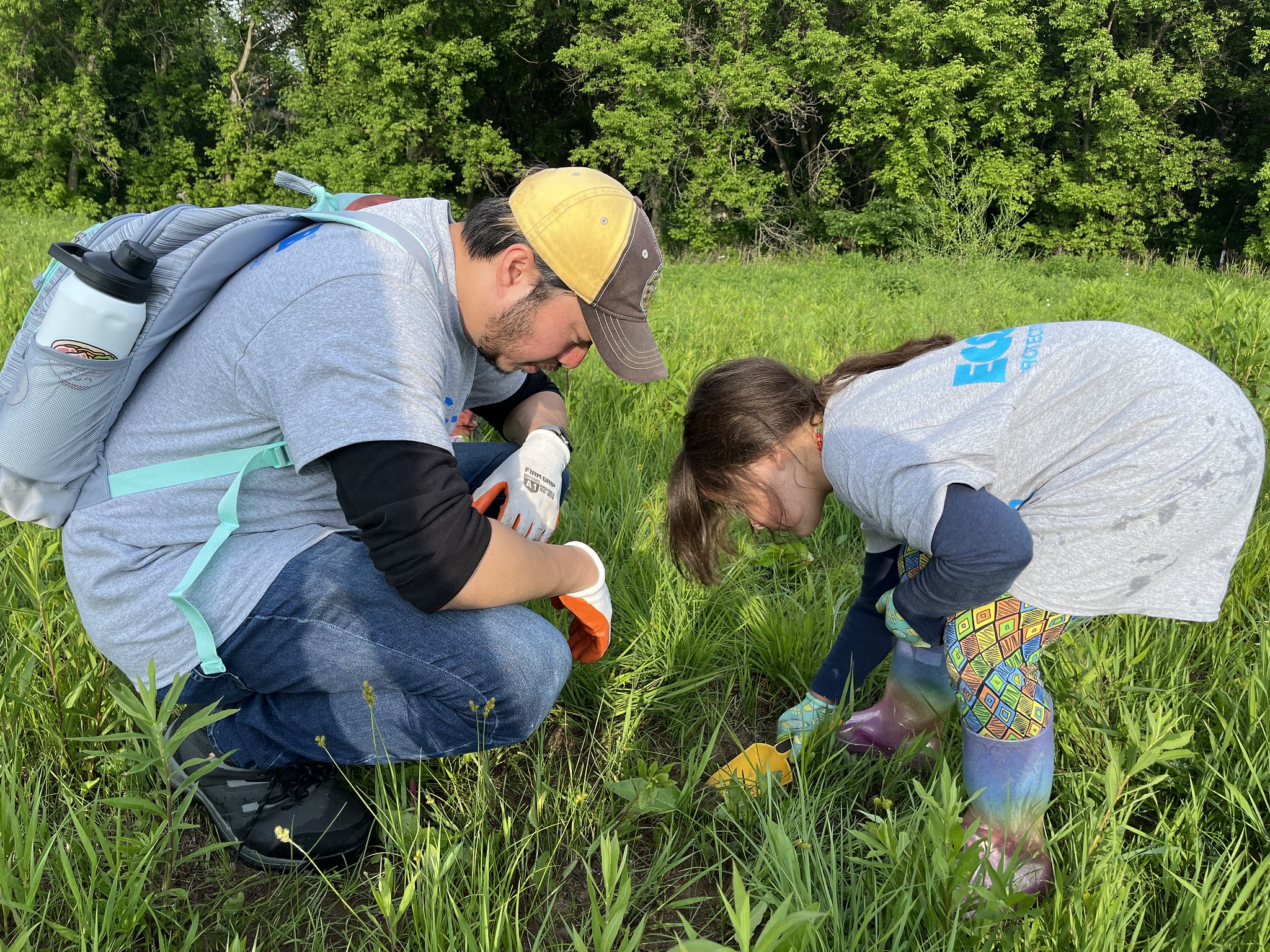 An adult and child dig a hole for planting