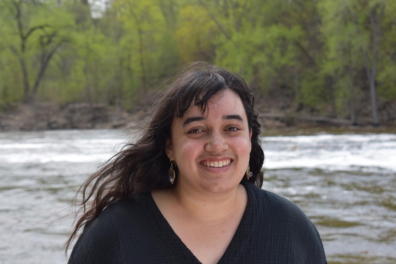 Sophie Downey smiling for the camera while standing in front of the Mississippi River.