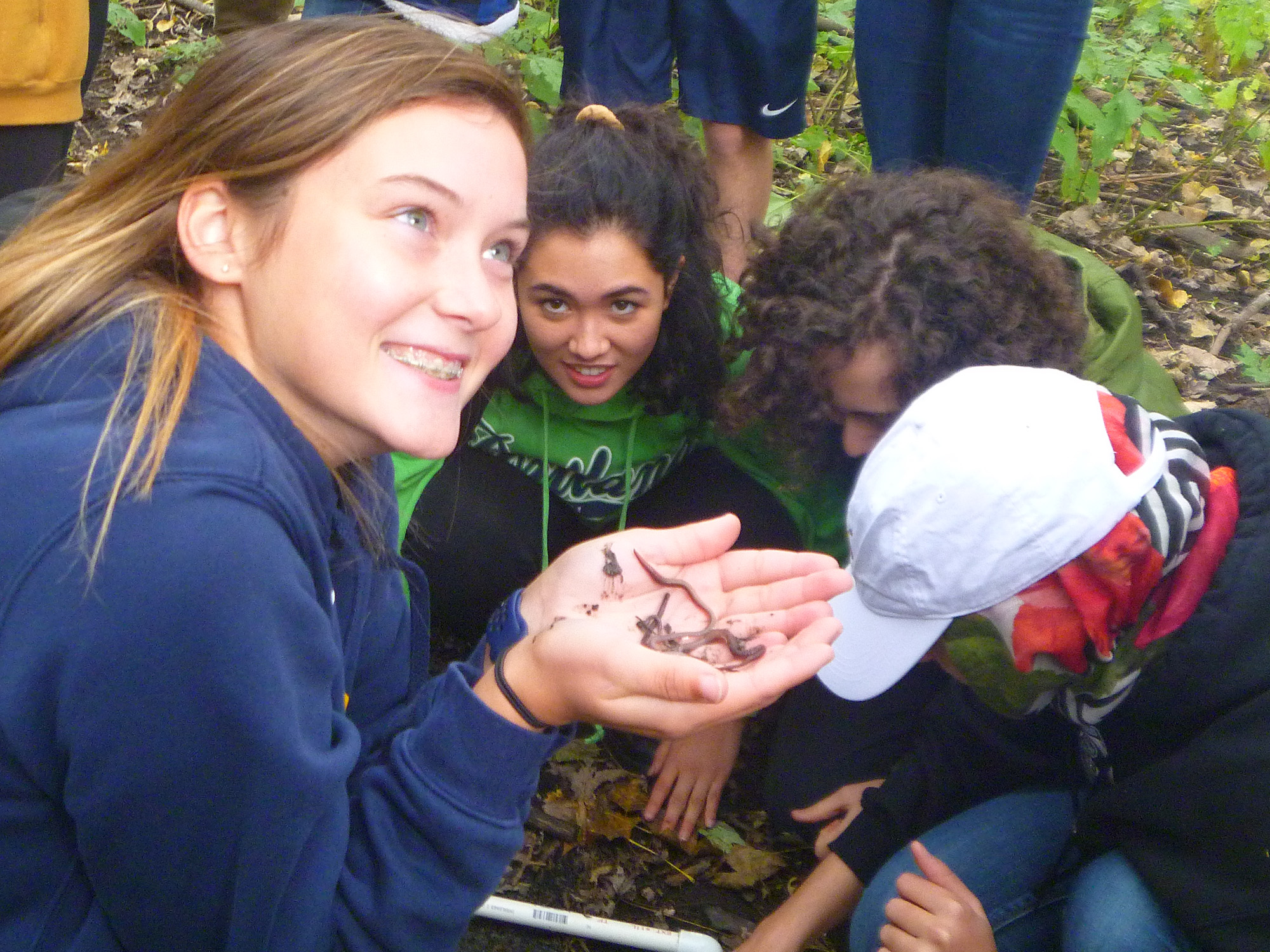 High school students hold earthworms