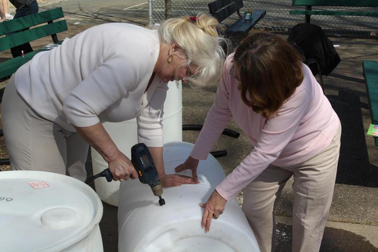Volunteers installing a rain barrel conversion kit
