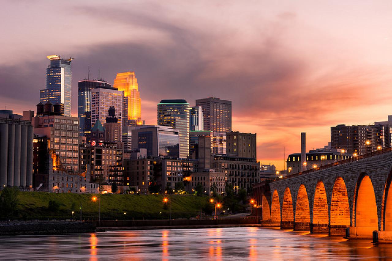 Downtown Minneapolis glows along the Mississippi at the end of the Stone Arch Bridge.