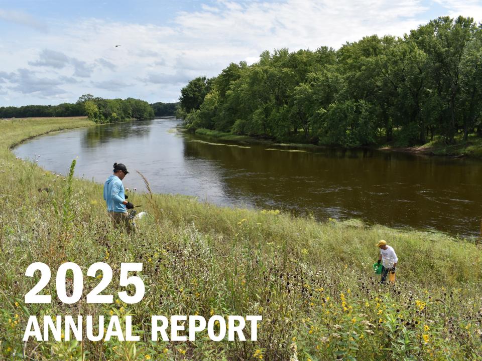 2025 Annual Report cover Two volunteers working in prairie by river, with text: 2025 Annual Report