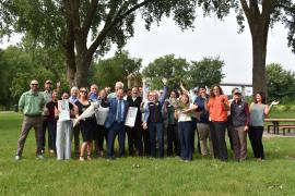 Coalition members, legislators and agency staff all pose for a celebratory photo outside at Harriet Island.