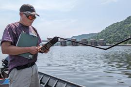 Dr. Peter Sorensen works from a boat on the river