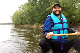 Adam Flett paddles a canoe