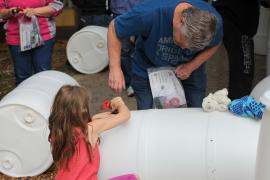Workshop participants assembling a rain barrel
