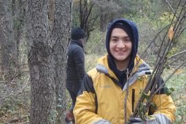 A volunteer poses with buckthorn sticks at a past Ravine Park brush haul