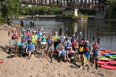 Paddle, restore and learn the gorge 2025 Kayaker volunteers with paddles on the river shore