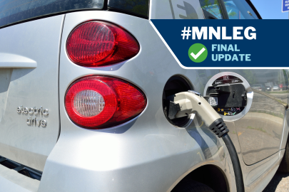 An electric car with its charging port open and a charging cord inserted.
