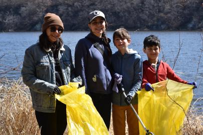 Volunteers with bags stand by river