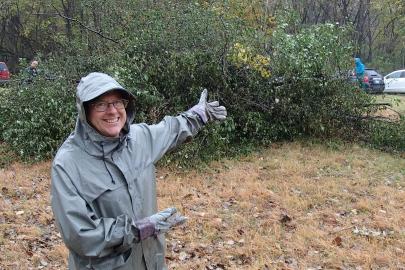 A volunteer showing off the large pile of brush that was the result of a hard day's work at last year's event.