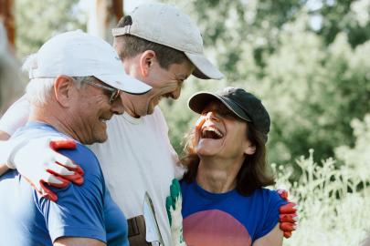 Three volunteers hug and smile