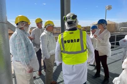 People in protective gear listen to a speaker