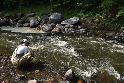 Person in waders samples a stream