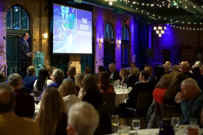 Whitney speaks at podium in front of gala crowd