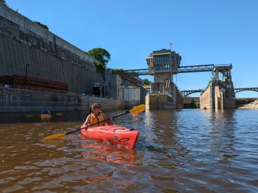 A kayaker paddles away from Lock and Dam 1 on a sunny June day in 2022.