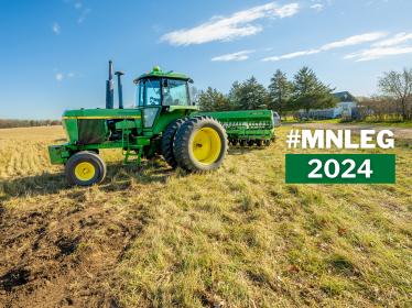 A farmer drives a combine harvester over a field of Kernza. Text over the image says "MNLEG 2024"