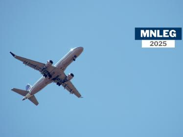 A plane flying against a blue sky. Text says "MNLEG 2025"