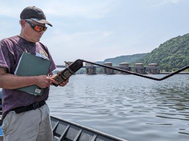 Dr. Peter Sorensen works from a boat on the river