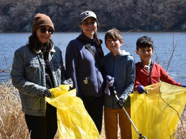 Volunteers with bags stand by river