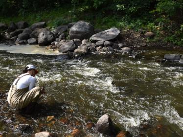Person in waders samples a stream