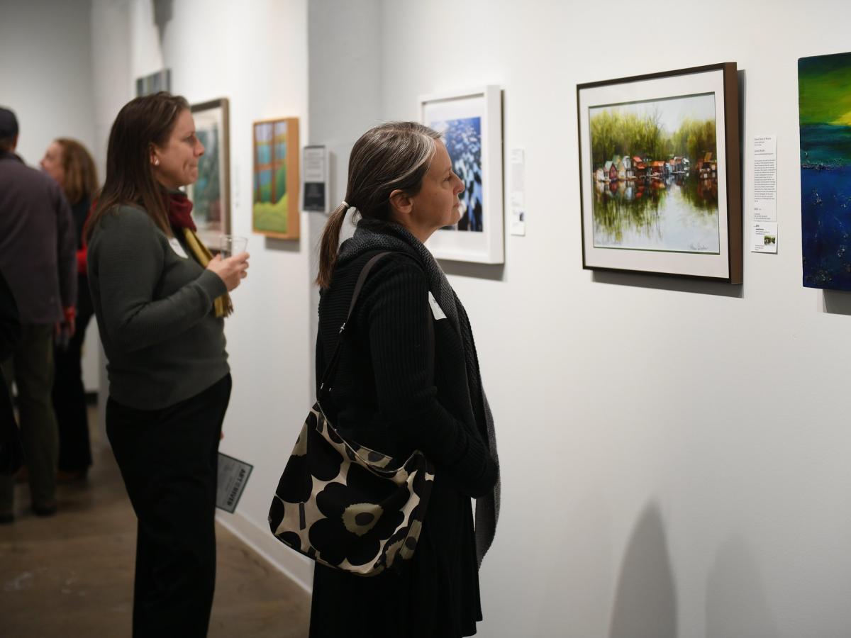Two attendees look at artwork