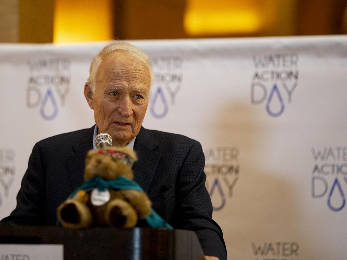 David Durenberger, in a suit and speaking behind a microphone at Water Action Day at the Minnesota Capitol rotunda in 2018. 