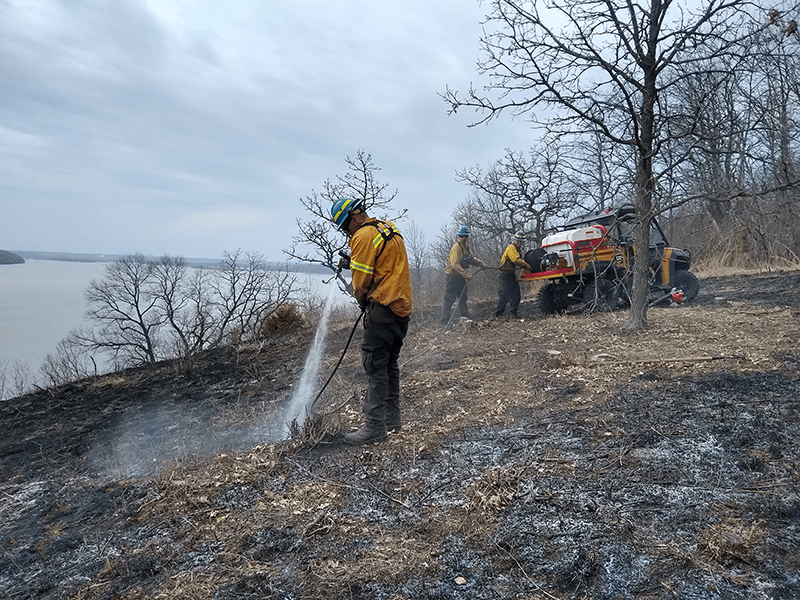 Person hoses down smoldering land