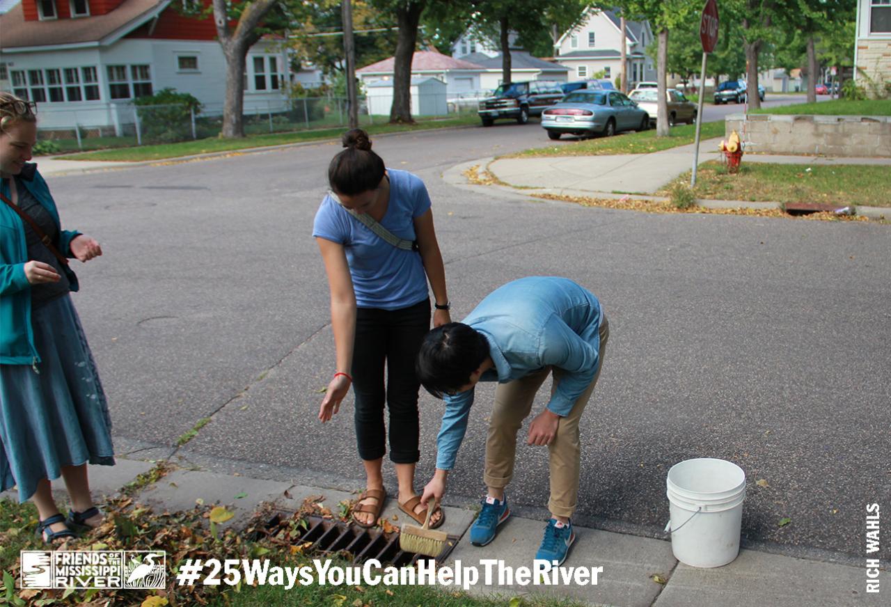 People cleaning out stormwater drain